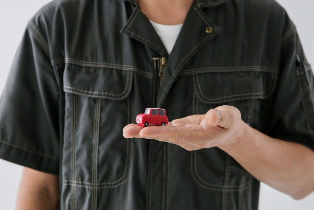 おもちゃの車を持った修理業者