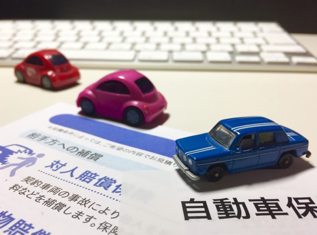 おもちゃの車と保険の書類とキーボード